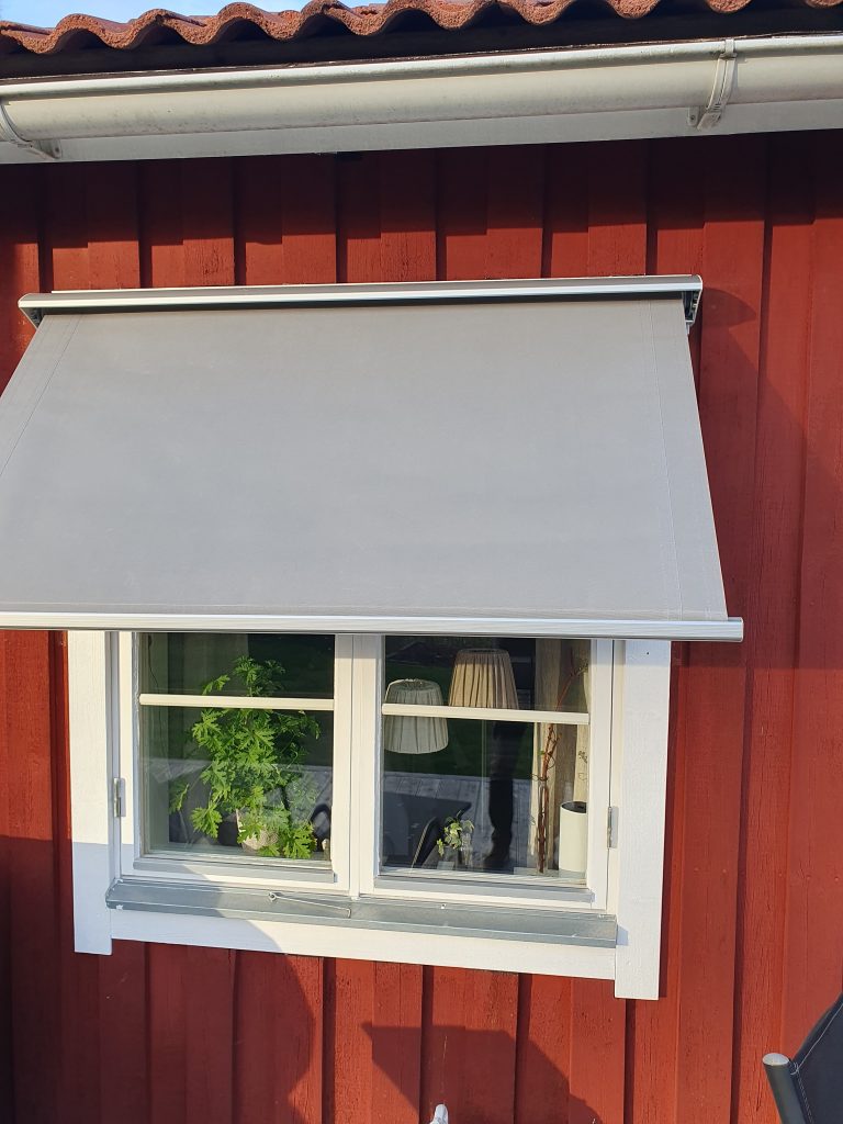 klassisk grå markis på rött hus