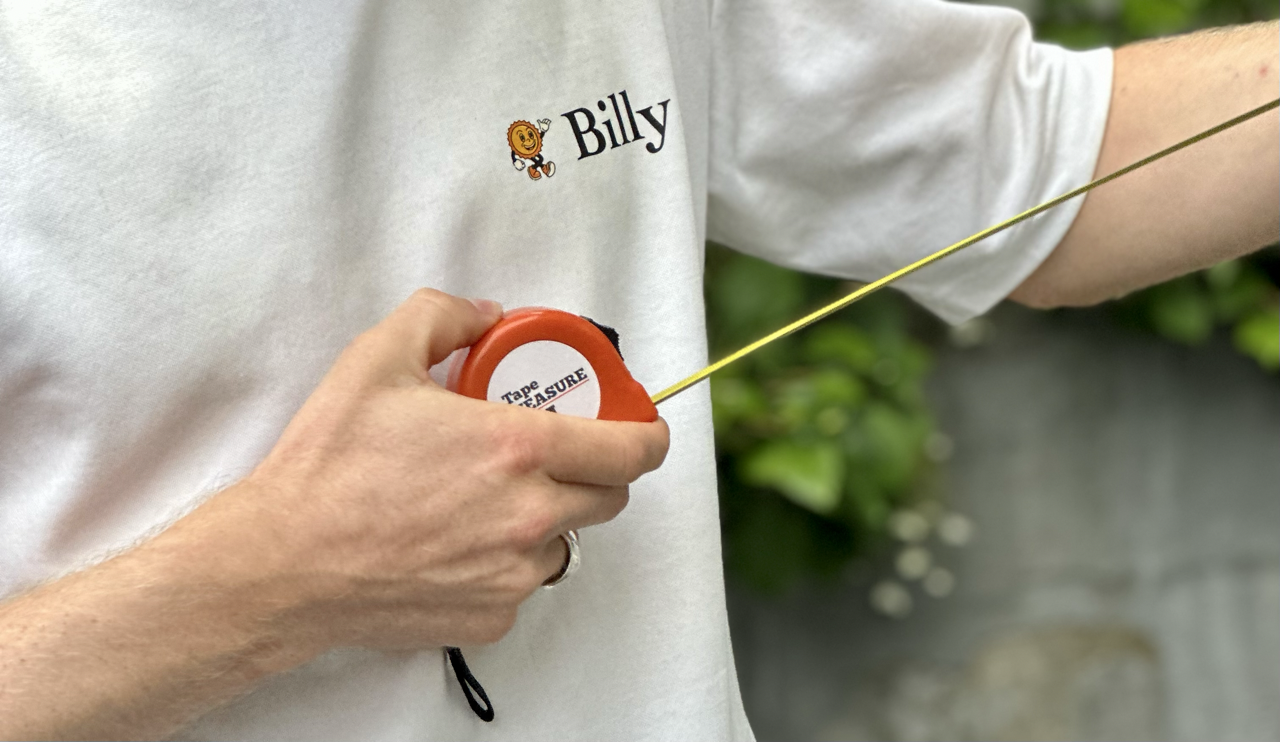 Person mäter bredd med måttband inför beställning av terrassmarkis
