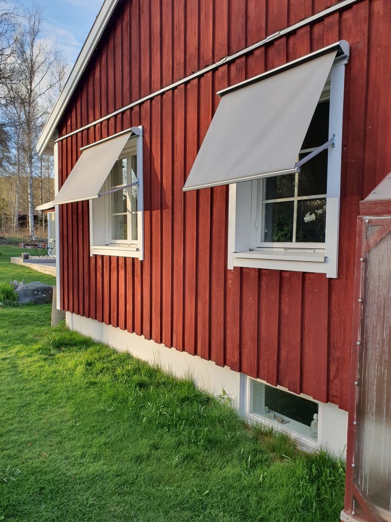 Grå markiser på rött hus