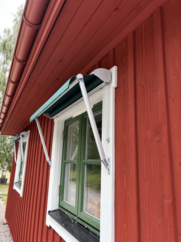 En grön markis på ett rött hus