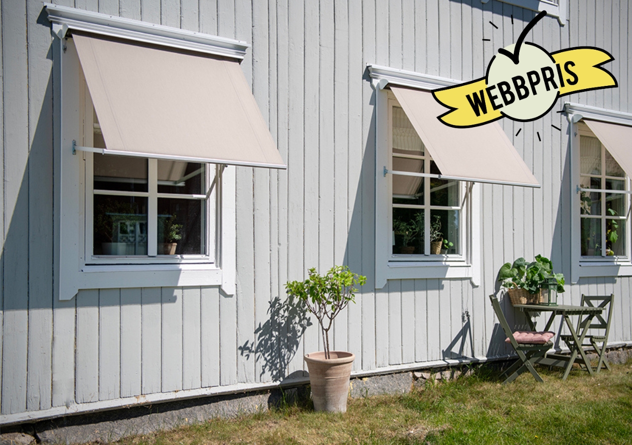 Beige fönstermarkis 120x80 cm med motor, monterad på grå trävilla. Prisvärt och måttanpassat solskydd från BILLY Markiser i slitstark akrylväv med UV-skydd. Kombinerar modern komfort, hållbarhet och klassisk design.