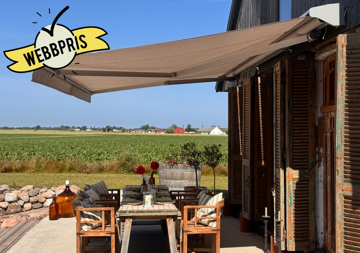 Beige terrassmarkis 4 m med motor och kassett, monterad på brun villa. Ett prisvärt solskydd från BILLY Markiser som skapar skugga över matplatsen utomhus. Slitstark akrylväv, modern design och enkel elstyrning för bekväm användning.