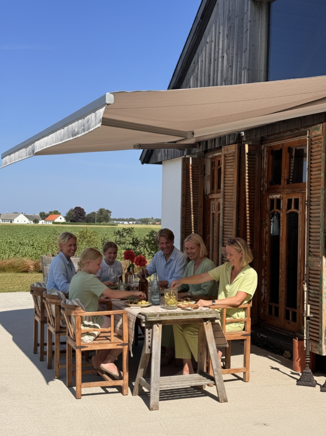 Brun måttanpassad terrassmarkis 400 cm med motor och beige väv, monterad på brunt hus. Skapar behaglig skugga över matplatsen på terrassen. En elegant, motordriven markis från BILLY för komfort och stil i utomhusmiljö.