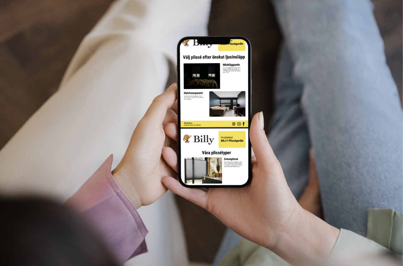 par som håller i en produktbroschyr från Billy om Billys plisségardiner